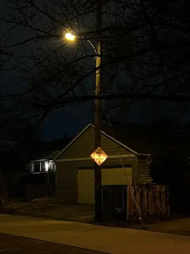 Streetlight's warm glow piercing the quiet, dark night.